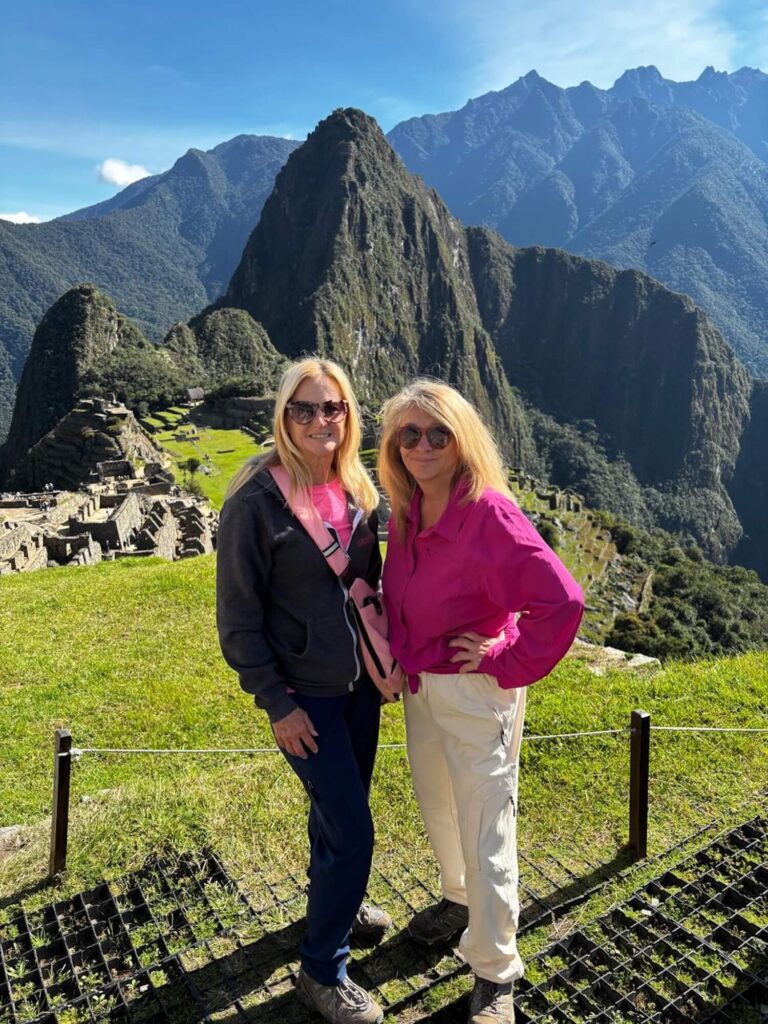 Couple enjoying the upper platform panoramic view of Machu Picchu and Huayna Picchu