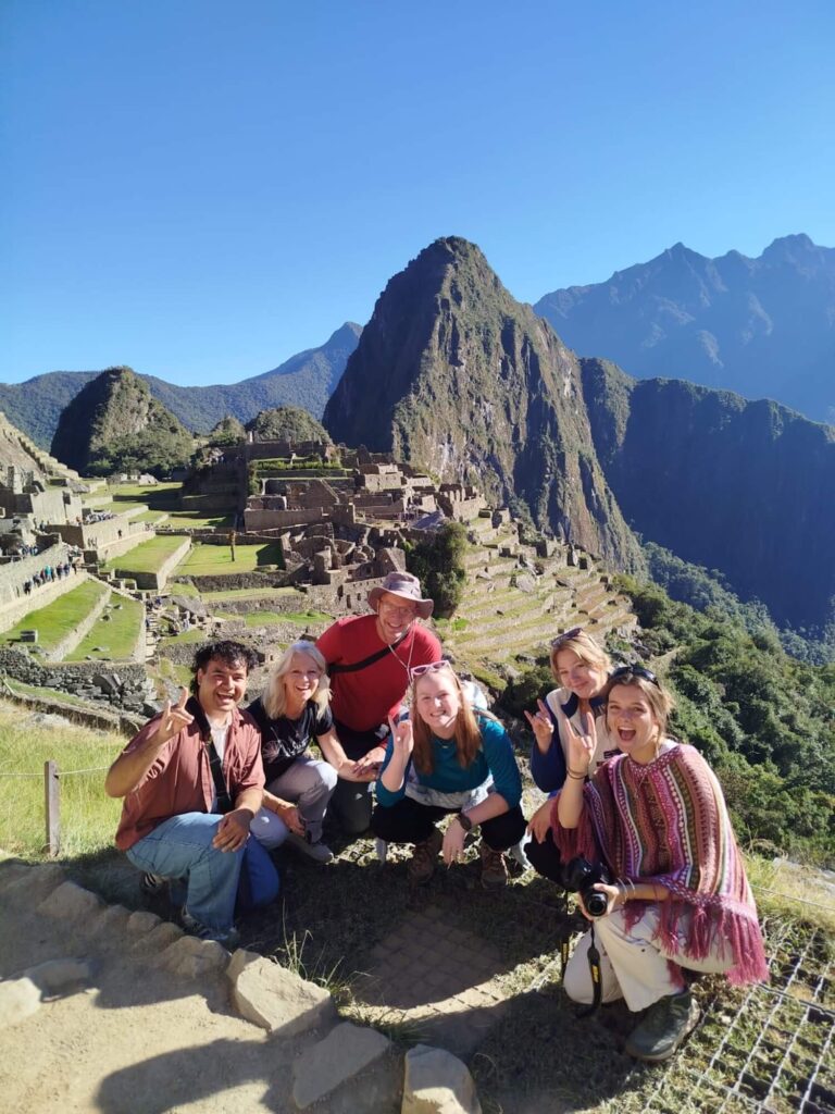 Group tour photo at the classic Machu Picchu viewpoint with Huayna Picchu mountain in the background